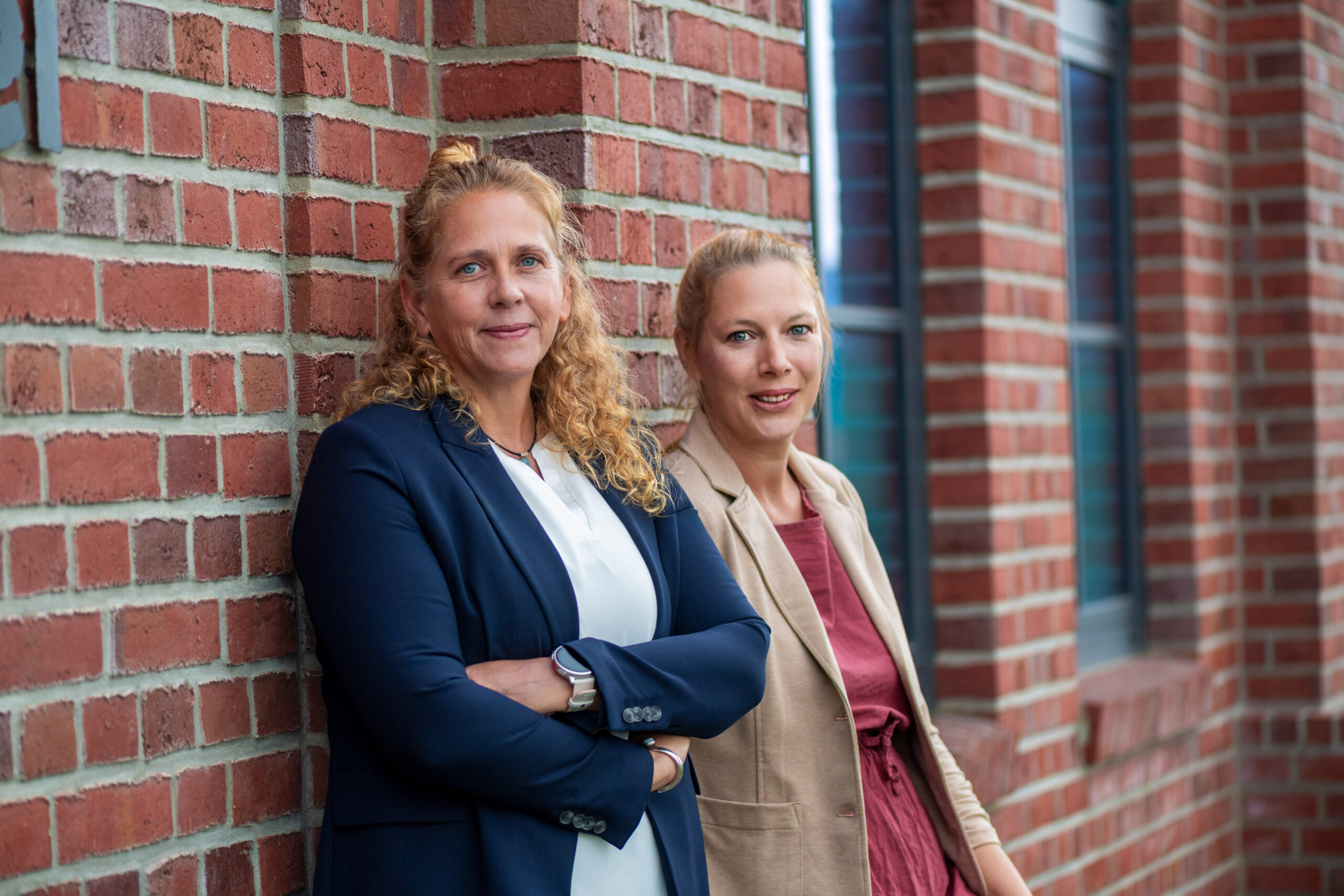 2 Frauen vor einer Wand